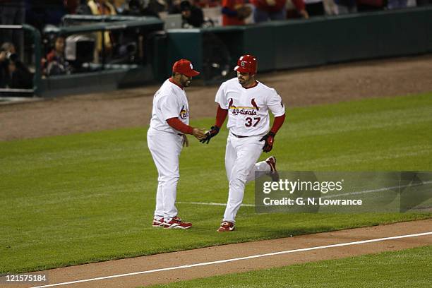 Jeff Suppan is greeted by Jose Oquendo after hitting a home run during game 3 of the NLCS between the New York Mets and St. Louis Cardinals at Busch...