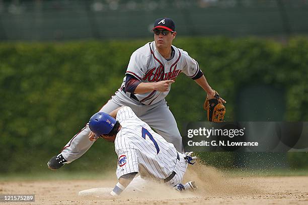 Marcus Giles of the Braves throws to complete a double play during action between the Atlanta Braves and Chicago Cubs at Wrigley Field in Chicago,...