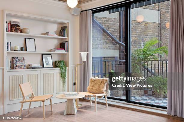 Sitting area with access to balcony of Mortimer House, Fitzrovia. Mortimer House, Fitzrovia, United Kingdom. Architect: AvroKO, 2018..