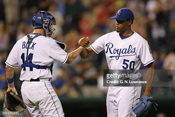 Relief pitcher Ambiorix Burgos is congratulated by John Buck after the Royals defeated the Pittsburgh Pirates 10-6 at Kauffman Stadium in Kansas...