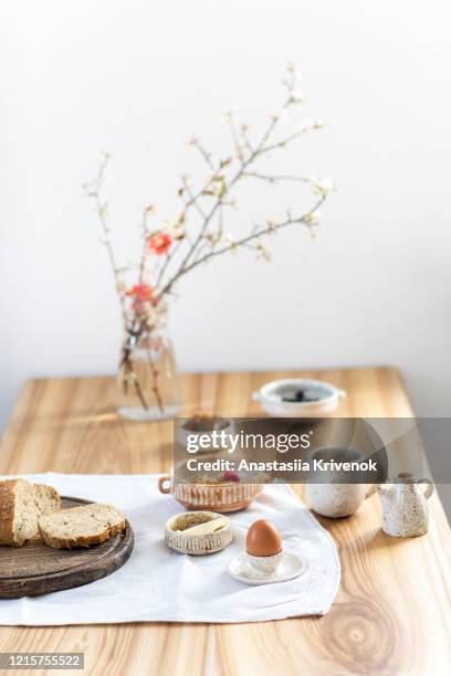 beautifully styled wood dining table set for breakfast. natural and organic breakfast with fresh bread, egg, muesli, coffee and flowers on linen tablecloth in ceramic dishware. copy space. - morning wood 個照片及圖片檔