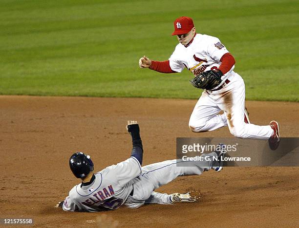 Carlos Beltran of the Mets is forced out at 2nd base as David Eckstein leaps in the air during game 5 action of the NLCS between the New York Mets...