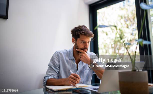 hombre woriking desde casa. - hombre revision fotografías e imágenes de stock