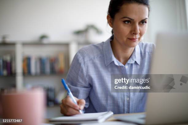mature woman working from home during covid-19 pandemic - tutorial stock pictures, royalty-free photos & images