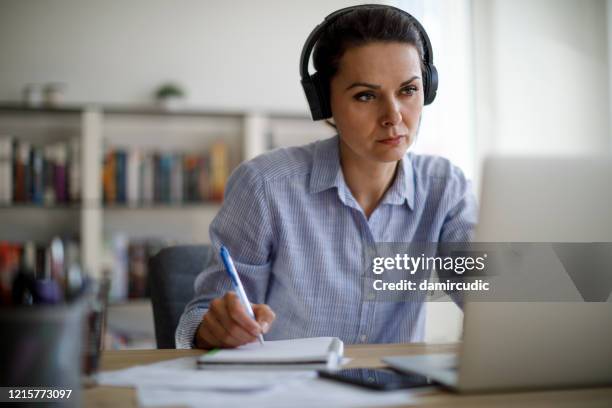 reife frau arbeitet von zu hause während covid-19 pandemie - ausbildung büro stock-fotos und bilder