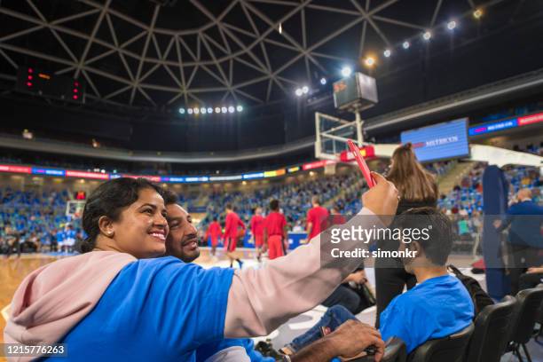 espectadores tomando selfie - basketball stadium fotografías e imágenes de stock