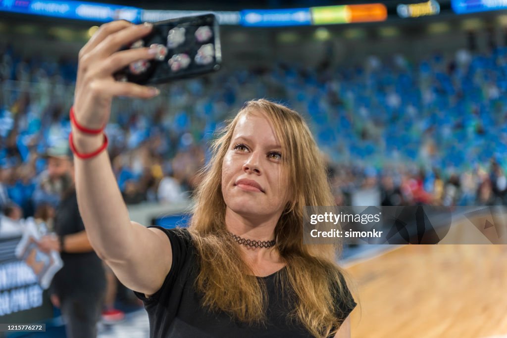 Female spectator taking selfie