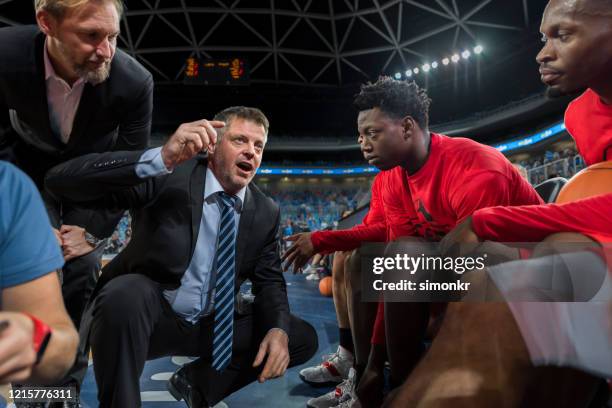 coach giving instructions to basketball team - basketball team work stock pictures, royalty-free photos & images