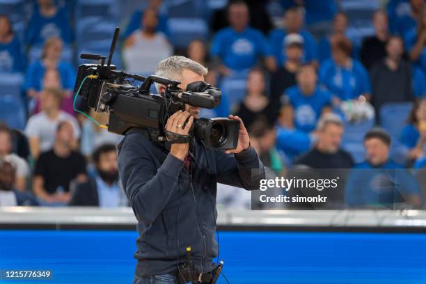 male cameraman shooting basketball game - operador de câmara imagens e fotografias de stock