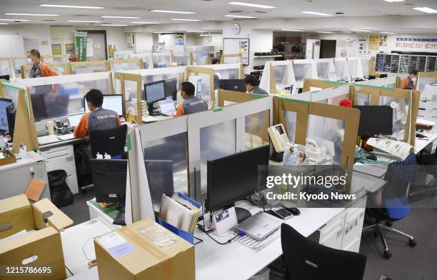 Photo taken May 21 shows makeshift partitions placed on desks at an emergency dispatch center of Tokyo Gas Co. In the Japanese capital as part of its...