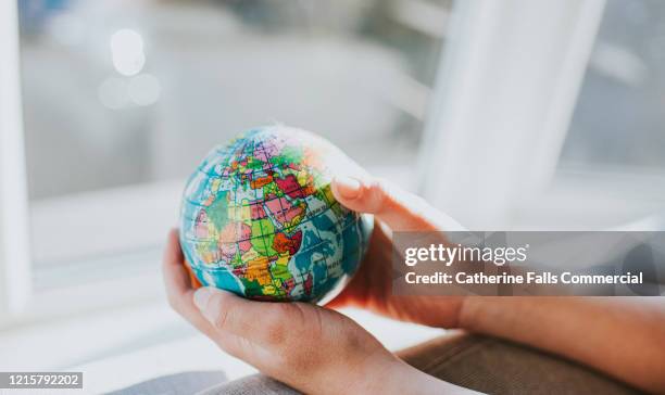 holding globe - covid economy stock pictures, royalty-free photos & images