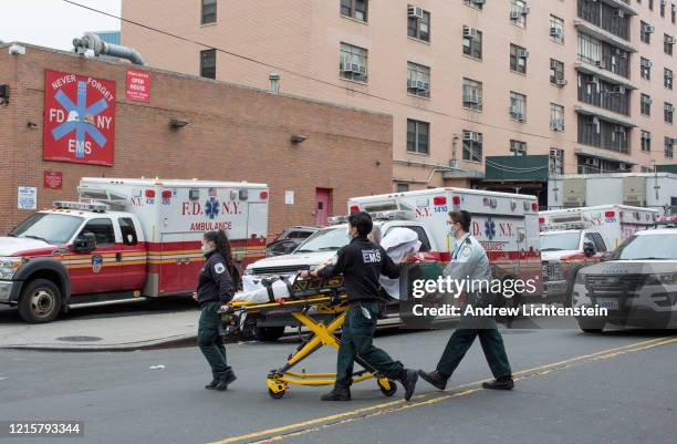 The scene outside of Elmhurst Hospital's trauma unit remains busy, with ambulances frequently leaving and arriving, dropping off patients, many who...