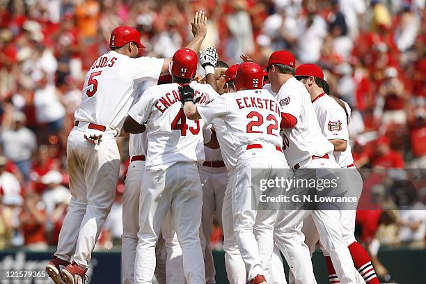 Cardinal players rush in to mob Scott Rolen after he hit a game-winning hit to drive in David Eckstein during action between the Los Angeles Dodgers...