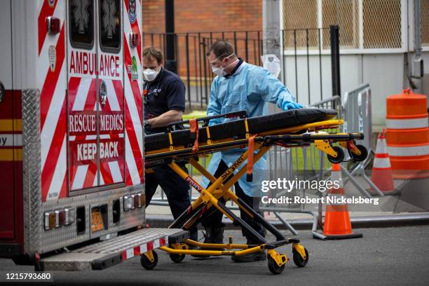 Two members of the Emergency Medical Team of the Fire Department of New York prepare their gurney before going on another ambulance call at the...