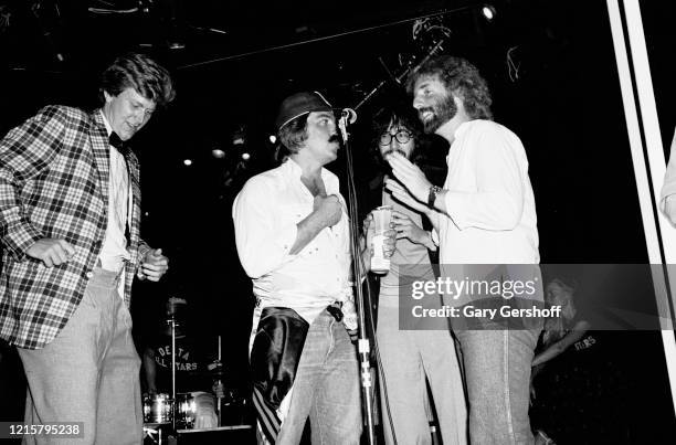 View of, from left, American actor James Widdoes, actor Bruce McGill, film director John Landis, and musician Andrew Gold as they perform onstage at...