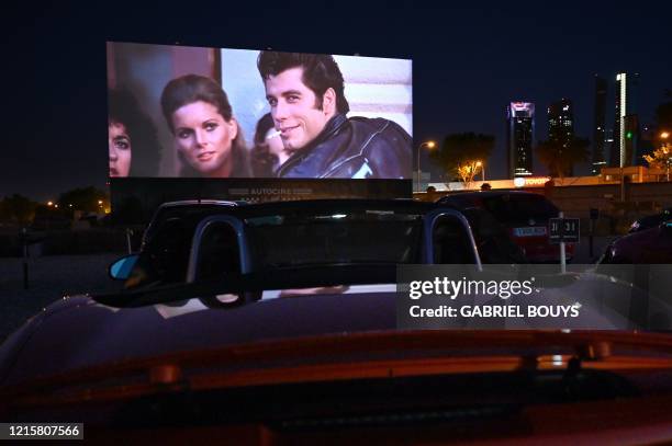 Cinema-goers in their cars attend the screening of the US musical romantic comedy film "Grease" during the reopening of the Autocine Madrid Race...