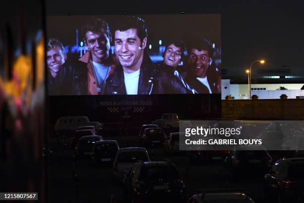 Cinema-goers in their cars attend the screening of the US musical romantic comedy film "Grease" during the reopening of the Autocine Madrid Race...