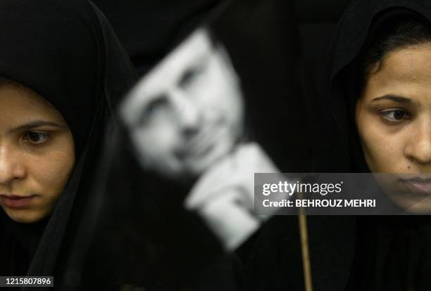 Iranian women attend a rally held by presidential candidate Mohammad Baqer Ghalibaf, a 43-year-old hardline former police chief, while holding his...