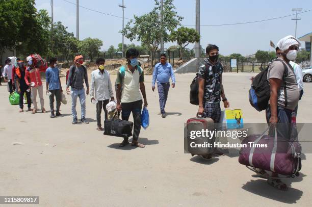 Migrants head to board Haryana Roadways transit buses to Gurugram railway station on their way to board a Jharkhand bound Shramik Special train, at...