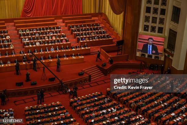 Chinese president Xi Jinping is seen on a large screen as Communist Party delegates take part in a session after voting on a new draft security bill...
