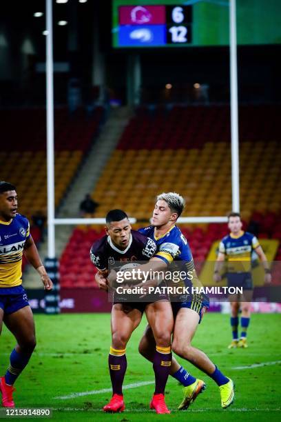 Brisbane Broncos' player Jamayne Isaako is tackled by Parramatta Eels' player Waqa Blake during the Australian Rugby League match between the...