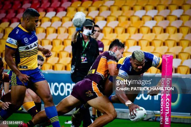 Parramatta Eels' player Maika Sivo scores a try as he is tackled by Brisbane Broncos' player Jesse Arthars during the Australian Rugby League match...