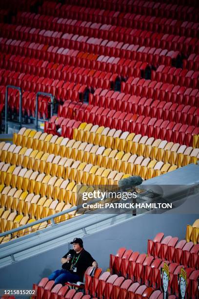 Lone radio journalist is seen amid empty seating during the Australian Rugby League match between the Brisbane Broncos and the Parramatta Eels, the...