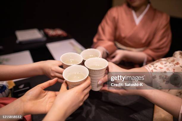 jovens mulheres em kimino celebração brindando em restaurante japonês - saquê - fotografias e filmes do acervo