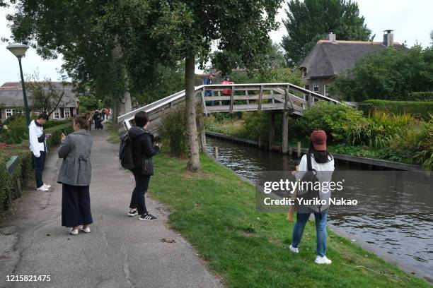 Chinese tourists makes pictures along a canal on September 6 at Giethoorn town in the province of Overijssel, Netherlands. Giethoorn, also known as...