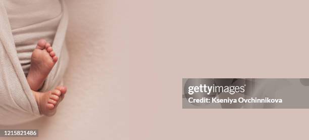 baby's feet exposed. legs up in the air. white and light green trousers. light gray background. - hands in the air heart stockfoto's en -beelden