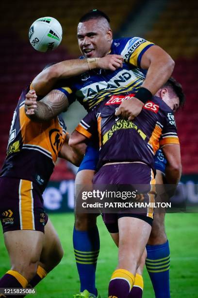 Parramatta Eels' player Junior Paulo loses the ball as he is tackled by Brisbane Broncos' player Jamil Hopoate and Brodie Croft during the Australian...