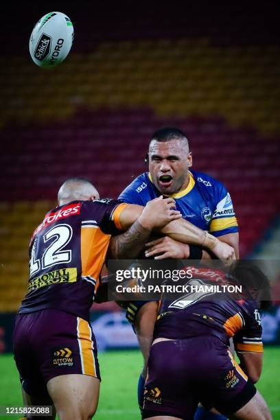 Parramatta Eels' player Junior Paulo loses the ball as he is tackled by Brisbane Broncos' player Jamil Hopoate and Brodie Croft during the Australian...