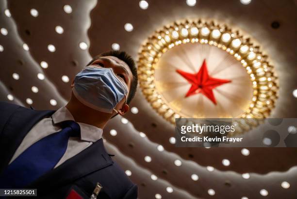 Chinese security officer wears a protective mask at the end of the closing session of the National People's Congress at the Great Hall of the People...