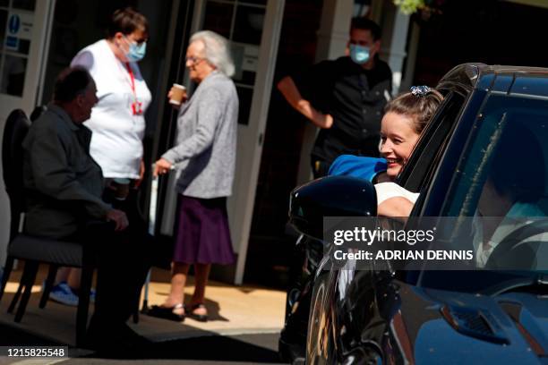 Girl talks with her grandmother Barbara Webster from her car window during a drive-through visit to Gracewell, a residential care home in Adderbury...