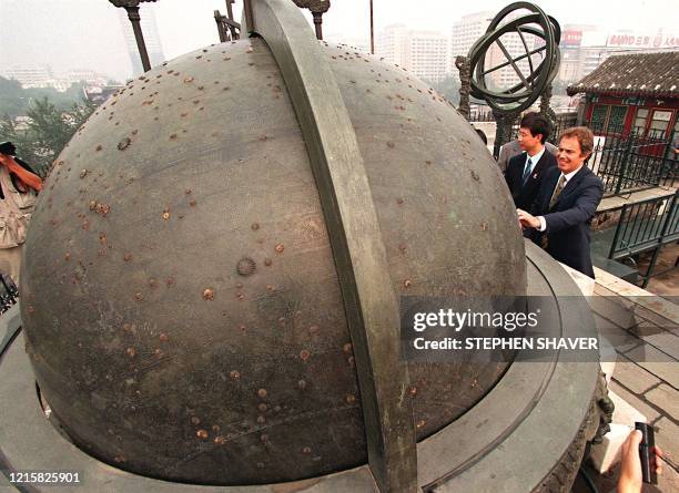 British Prime Minister Tony Blair touches an ancient Chinese astronomical instrument at the Chinese Ancient Observatory after an internet launch of a...