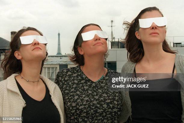 Des jeunes filles portent des lunettes spéciales, le 23 juillet 1999 à Paris, en vue de la dernière éclipse totale du siècle qui aura lieu le 11 août...