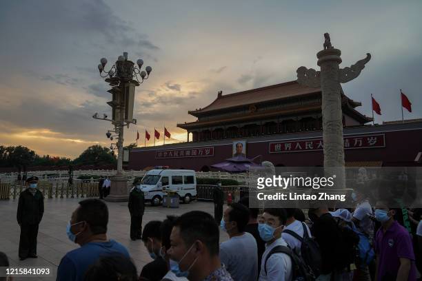 Visitors wearing protective face mask as they at Tiananmen Gate during the closing meeting of the third session of the 13th National People's...