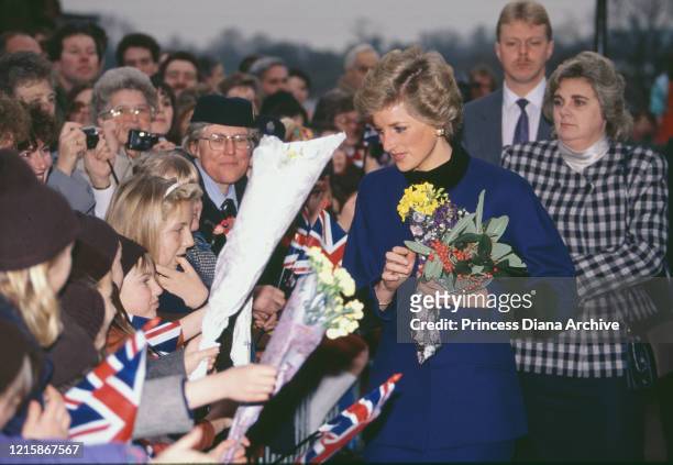 British royal Diana, Princess of Wales , wearing a blue outfit with black trim, carrying a small bouquet of flowers as she is greeted by well-wishers...