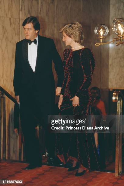 British royal Diana, Princess Of Wales , wearing a burgundy velvet evening dress by Catherine Walker, with a pearl necklace, attends the premiere of...