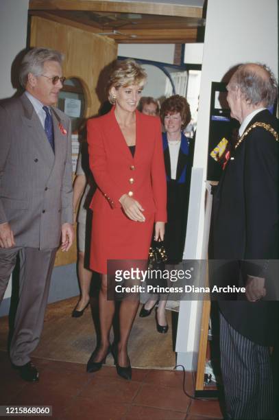 British royal Diana, Princess of Wales , wearing a red two-piece suit by Catherine Walker, meeting dignitaries during a visit to London Lighthouse, a...