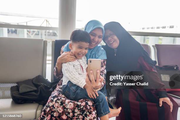 using smartphone at airport - airport sitting family stock pictures, royalty-free photos & images