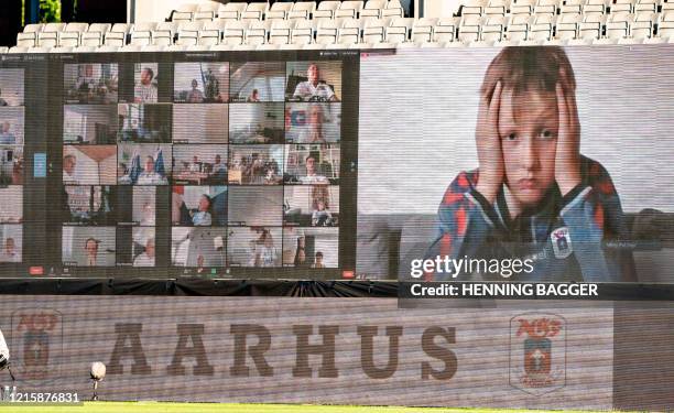 Young fan holds his head as fans are streamed live on to the screens on the sidelines during the 3F Super League football match between AGF and...