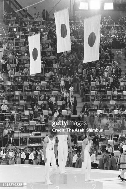 Bronze medalist Shigeru Kasamatsu of Japan, gold medalist Mitsuo Tsukahara of Japan and bronze medalist Sawao Kato of Japan wave to fans at the medal...