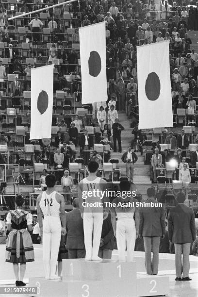 Bronze medalist Shigeru Kasamatsu of Japan, gold medalist Mitsuo Tsukahara of Japan and bronze medalist Sawao Kato of Japan stand on the podium or...