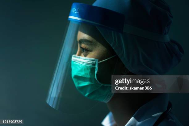 doctor in ppe suit uniform has stress in coronavirus outbreak  and emotional stress of overworked doctor and medical care team during covid-10 period. - pandemie photos et images de collection