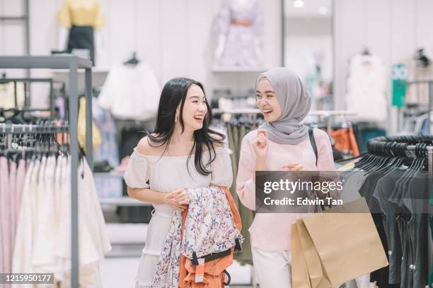 2 衣料品店で中国とマレー人の女性の買い物をし、購入するドレスを決定する新しい服を試着 - hijab girl ストックフォトと画像
