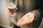 A hand holding a bunch of pills in an open palm