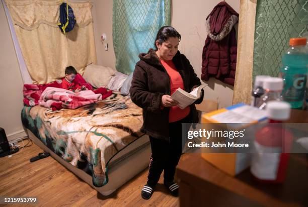 An undocumented Honduran immigrant reads her Bible during self-quarantine with her family for possible COVID-19 on March 30, 2020 in Mineola, New...