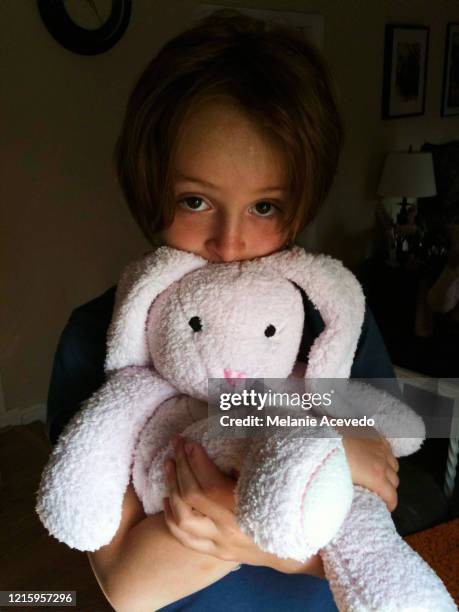 young redheaded girl short hair brown eyes and freckles close up holding white stuffed rabbit plush toy - old stuffed toy stock pictures, royalty-free photos & images