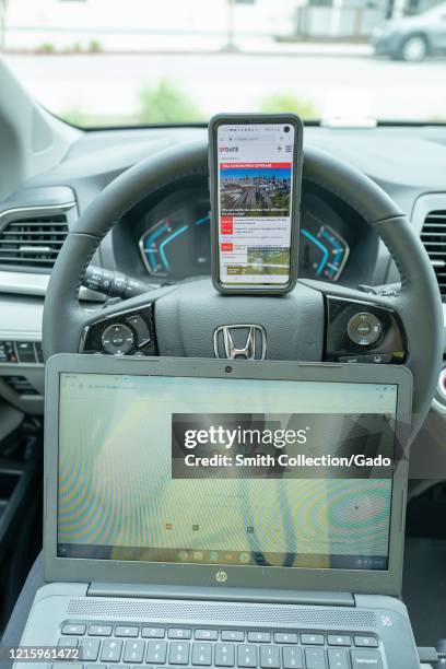 Remote work setup in automobile with cellphone and Chromebook laptop during COVID-19 coronavirus outbreak in San Francisco, California, March 30,...